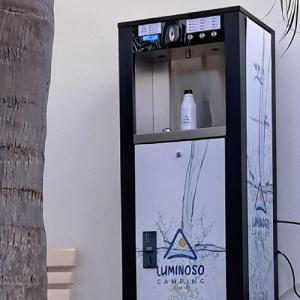 Refreshing water dispenser at a campsite, amidst nature and relaxation.