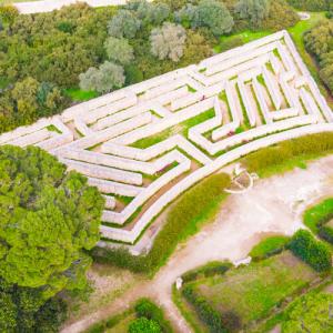Vue aérienne d'un labyrinthe en pierre entouré de verdure.