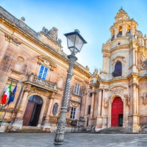 Église baroque avec façade ornée et ciel bleu.