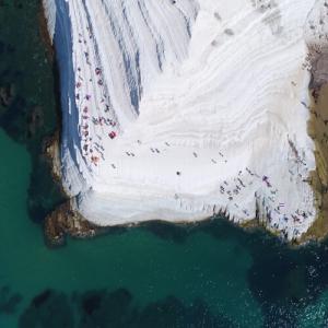 Falaise blanche surplombant la mer avec des touristes.